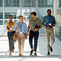Four individuals seated in chairs engaged in a business discussion during a meeting.