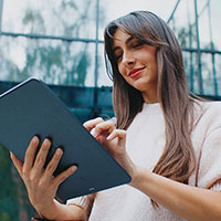 A business owner looking over her work while using a tablet
